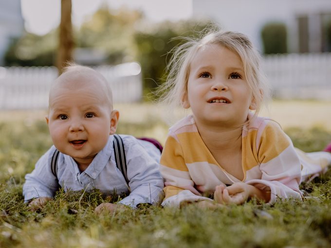 Aurelia und Vincent als kleine Kinder auf einer grünen Wiese